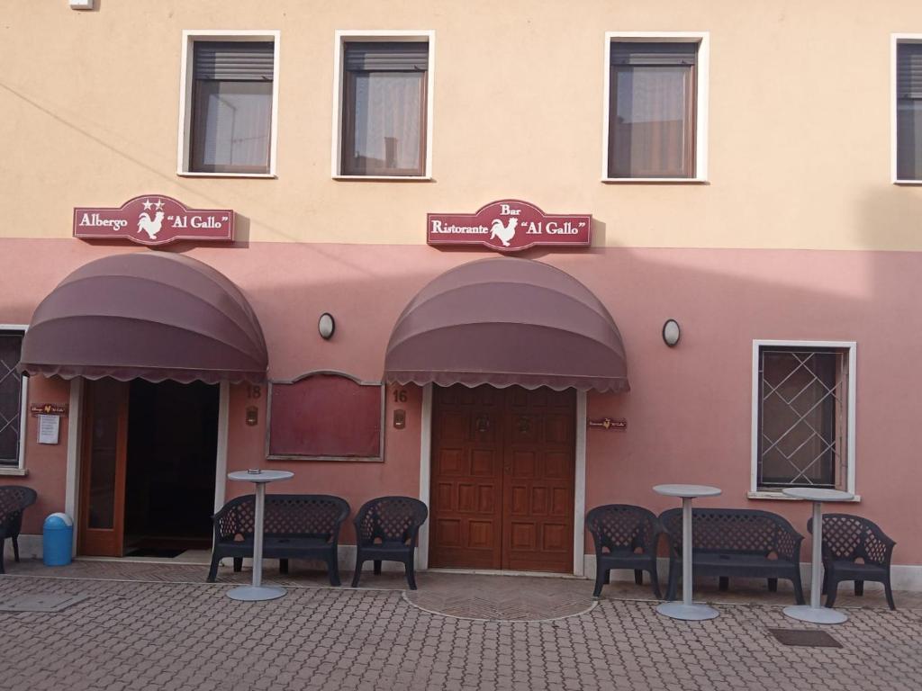 a pink building with chairs and tables in front of it at ALBERGO AL GALLO in Sanguinetto