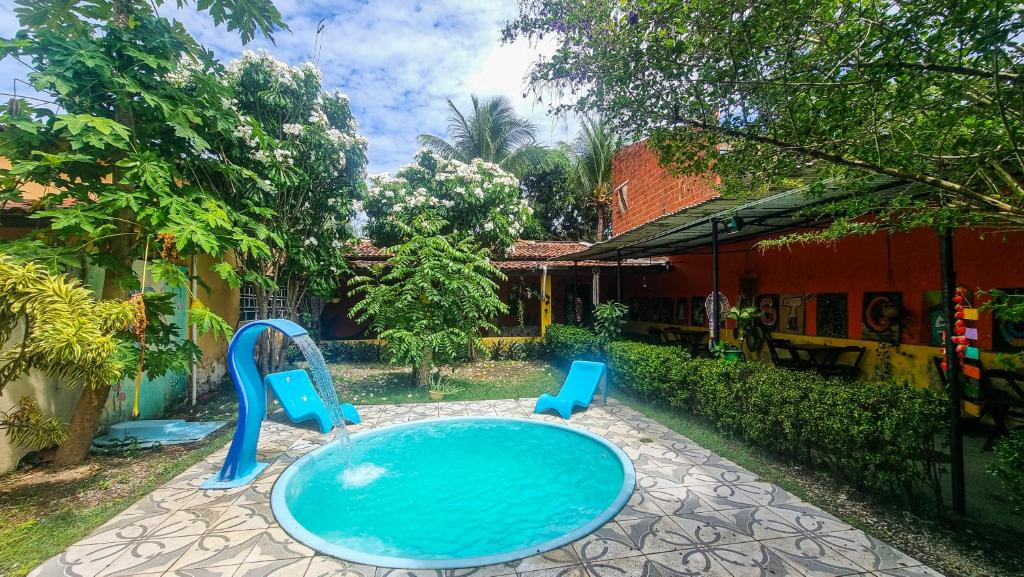 a pool with two blue chairs in a yard at Proxima Estacion Hostel in Maceió