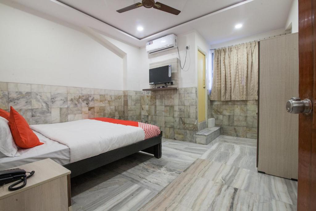 a bedroom with a bed and a tv on a wall at Hotel Holiday Rani Gunj Opp Punjab national bank in Secunderabad