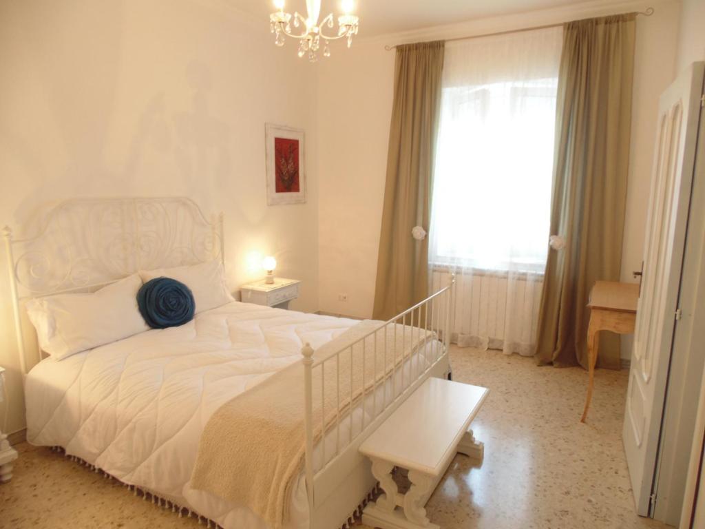 a bedroom with a white bed and a chandelier at Welcome to Alberobello in Alberobello
