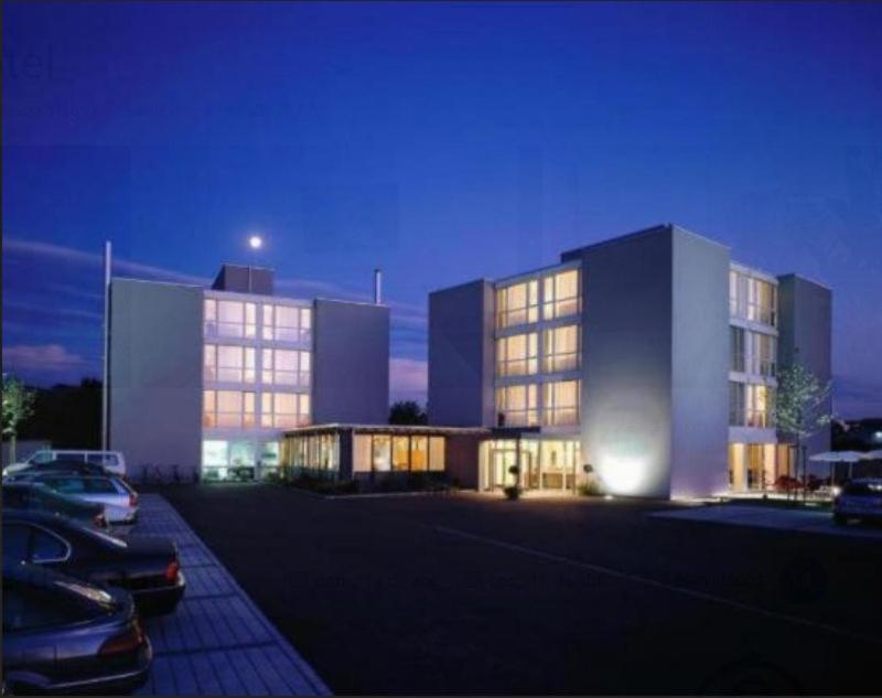 a large building with cars parked in a parking lot at Work Life Residence by Frauenfeld in Frauenfeld