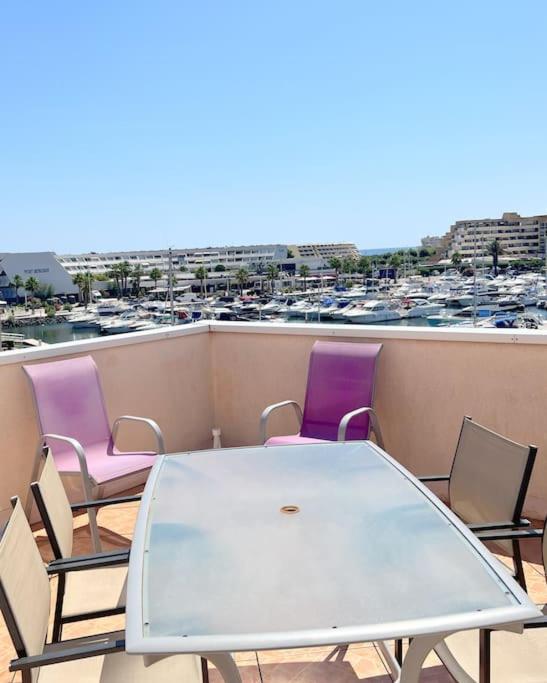 d'une table et de chaises sur un balcon avec vue sur le port. dans l'établissement Appartement 136, Port soleil village naturiste, au Cap d'Agde