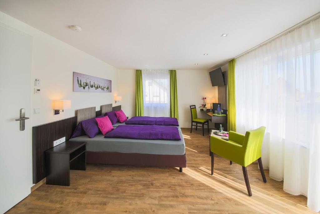 a bedroom with a purple bed and a green chair at Hotel Gästehaus Stock in Friedrichshafen