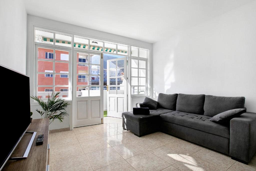 a living room with a couch and a large window at Atlantic Blue Dream Caletillas in Araya