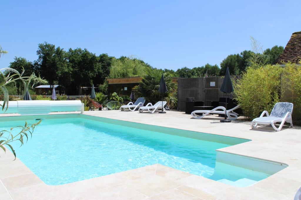 a swimming pool in a backyard with chaise lounge chairs at Ferme des Poulardieres in Crouy-sur-Cosson