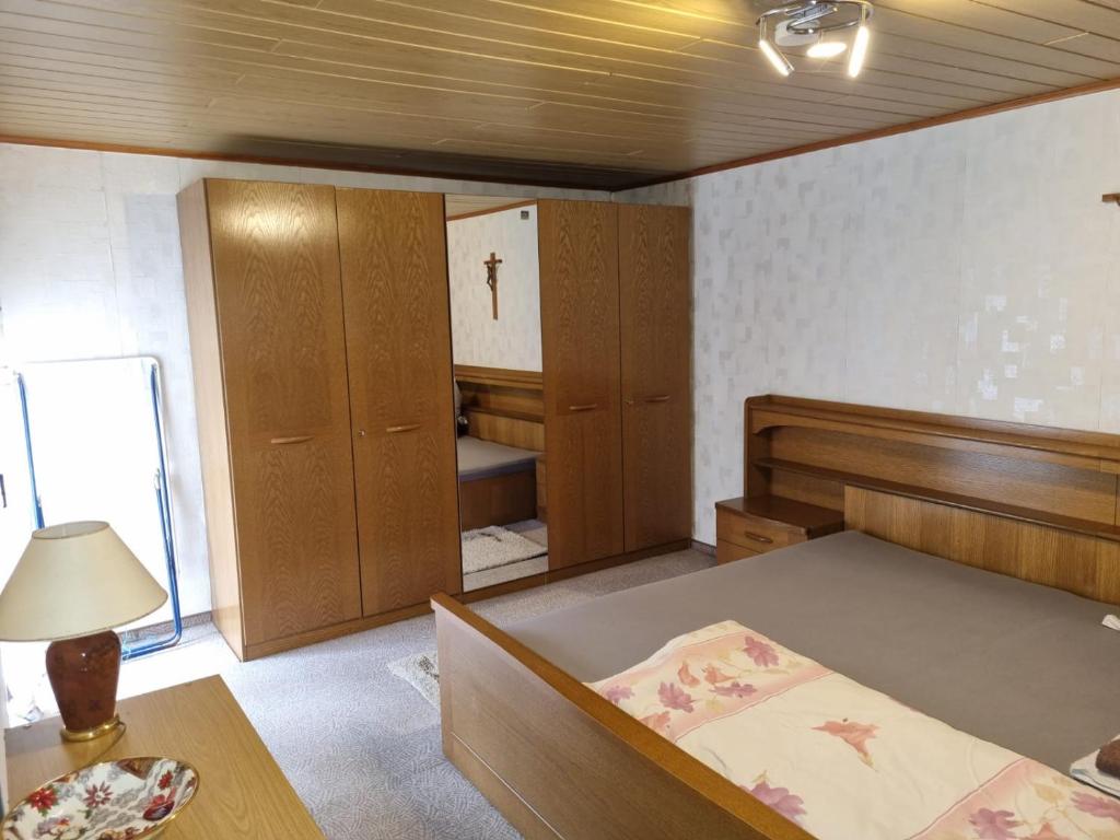 1 dormitorio con 1 cama, armarios de madera y mesa en Schönes Ferienhaus in Filsen, en Filsen