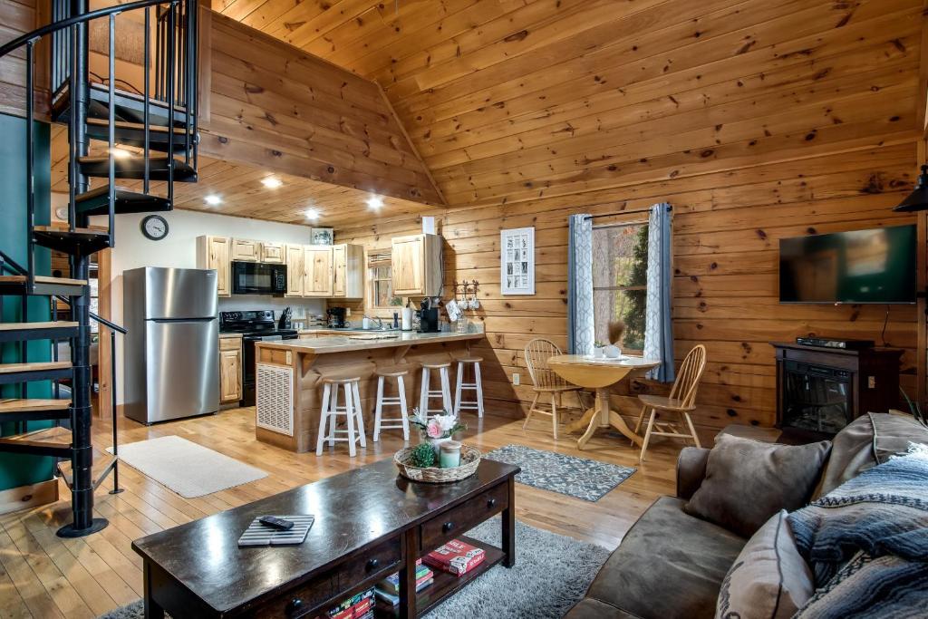 a living room and kitchen in a log cabin at Cozy Cabin Retreat: Tiny Trotter in Bryson City