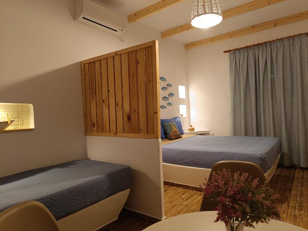 a hotel room with two beds and a table and a table sidx sidx at PERIVOLI 1-CHORA(5min away from the center by car) in Agkidia