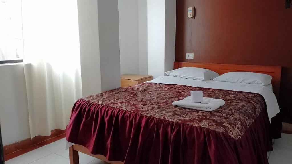 1 dormitorio con 1 cama con 2 toallas en hostal nazly, en Chachapoyas