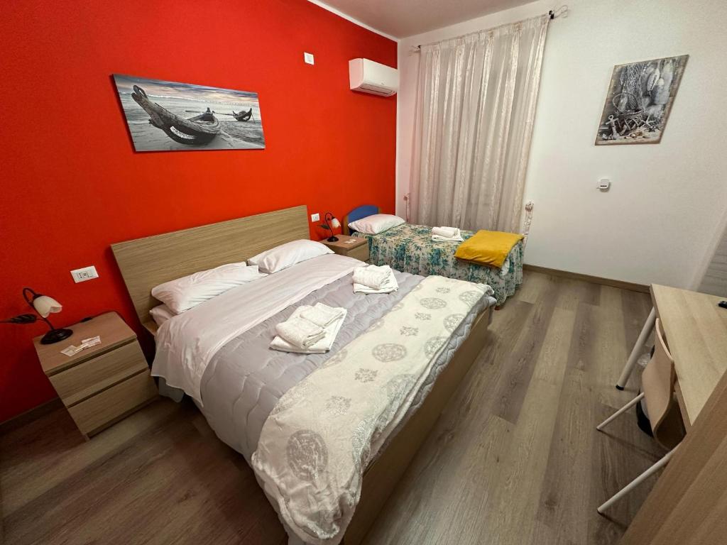 a bedroom with two beds and a red wall at Villa Maria in Lamezia Terme