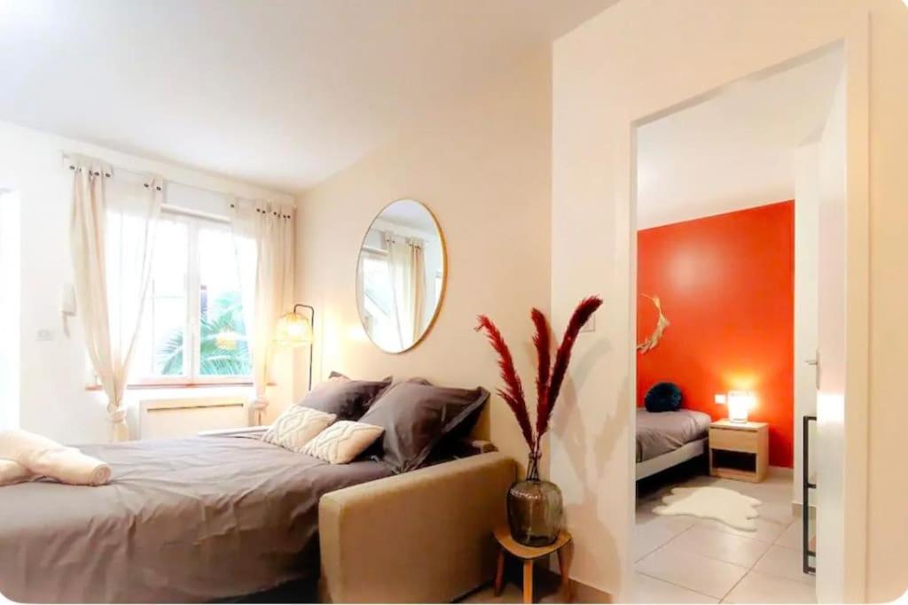 a bedroom with a large bed and a mirror at Chez Augustin T2 cosy in Montauban