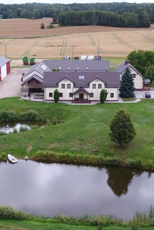 an aerial view of a large house with a pond at Pełnikowe Zacisze in Bobolice