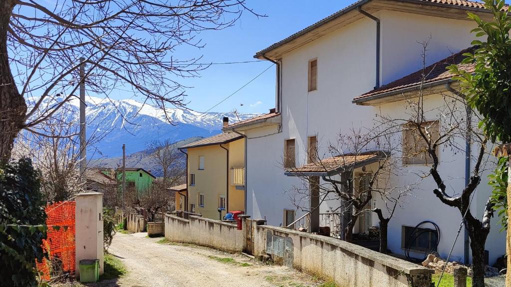 a street with houses and a mountain in the background at La Tana della Volpe in Tempera
