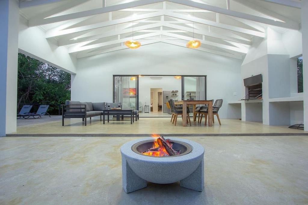 a living room with a fire pit in the middle at Maroela Safari House in Marloth Park