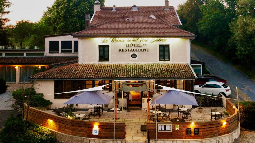 eine Luftansicht eines Hotelrestaurants mit Sonnenschirmen in der Unterkunft Logis Le Relais de la Voie Sacrée in Issoncourt