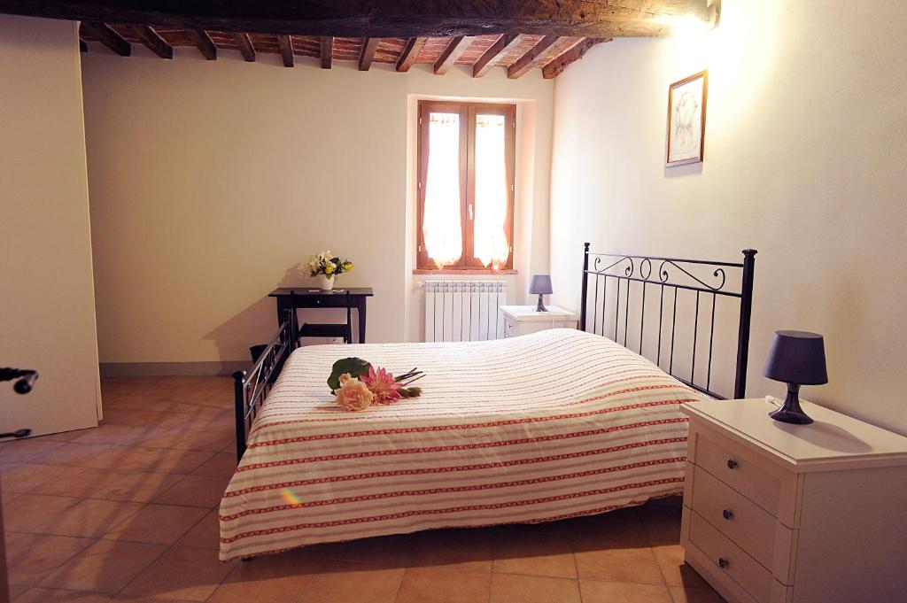 ein Schlafzimmer mit einem großen Bett und einem Fenster in der Unterkunft Il Dormiglione in Foiano della Chiana