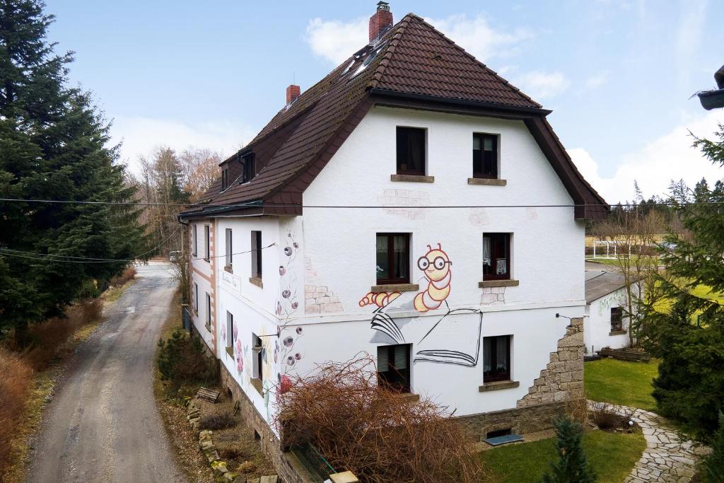 Una casa blanca con un cuadro a un lado. en Buchhaus Vier - Dachgeschoss en Kirchenlamitz