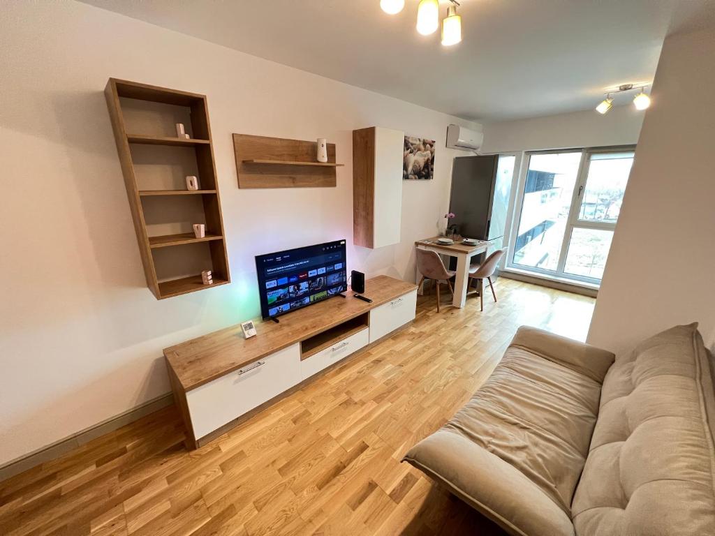 ヤシにあるAirport FlyHub Chic Apartmentのソファと薄型テレビのあるリビングルーム