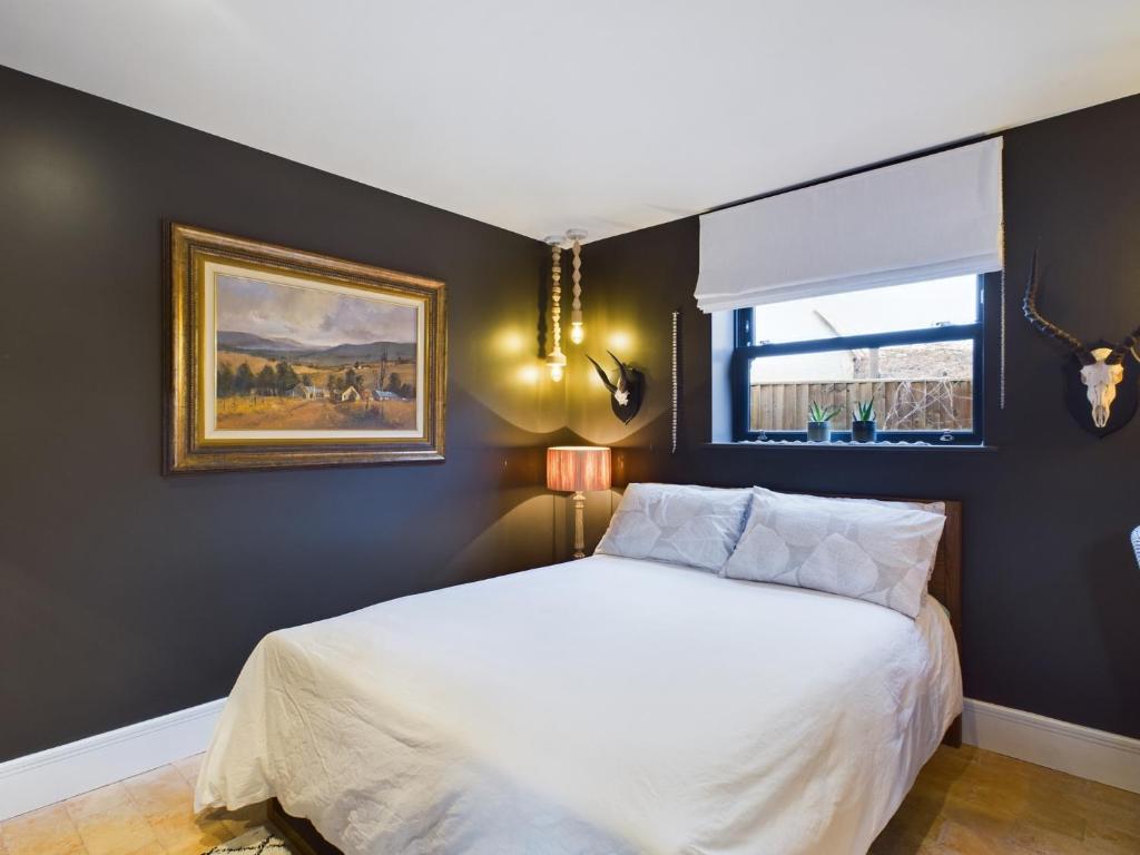 a bedroom with a bed and a painting on the wall at La Cassa Rossa Pittville Central Parking Modern Wifi in Cheltenham