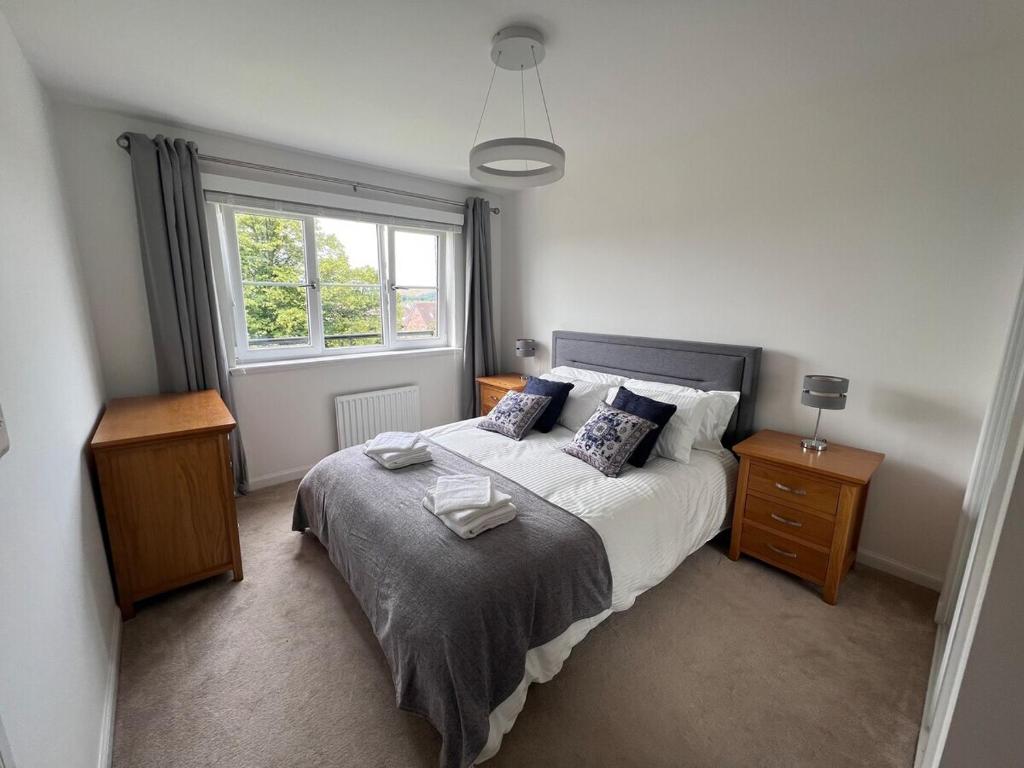 sypialnia z dużym łóżkiem i oknem w obiekcie Modern 2 Bedroom Flat in Quiet Village w/ Ensuite w mieście Bishopton
