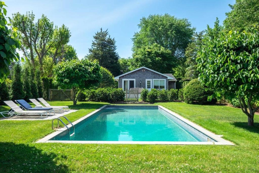 uma piscina no quintal de uma casa em Heated Pool, Driftwood Cottage by RoveTravel em East Hampton