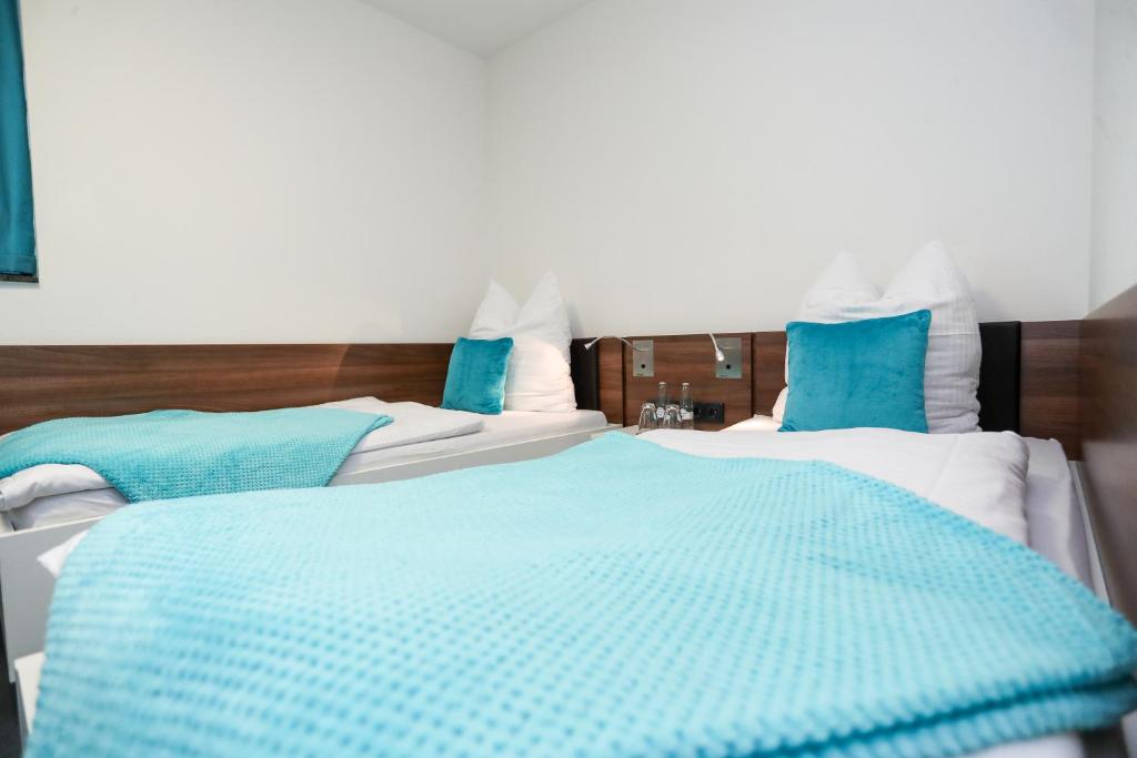 2 Betten in einem blau-weißen Zimmer in der Unterkunft Sportschule Wedau in Duisburg