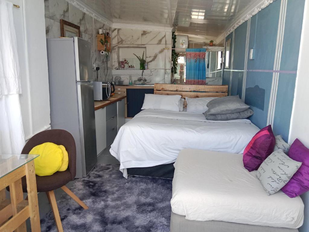 a small room with two beds and a kitchen at Cozy Private En Suite Studio in Cape Town