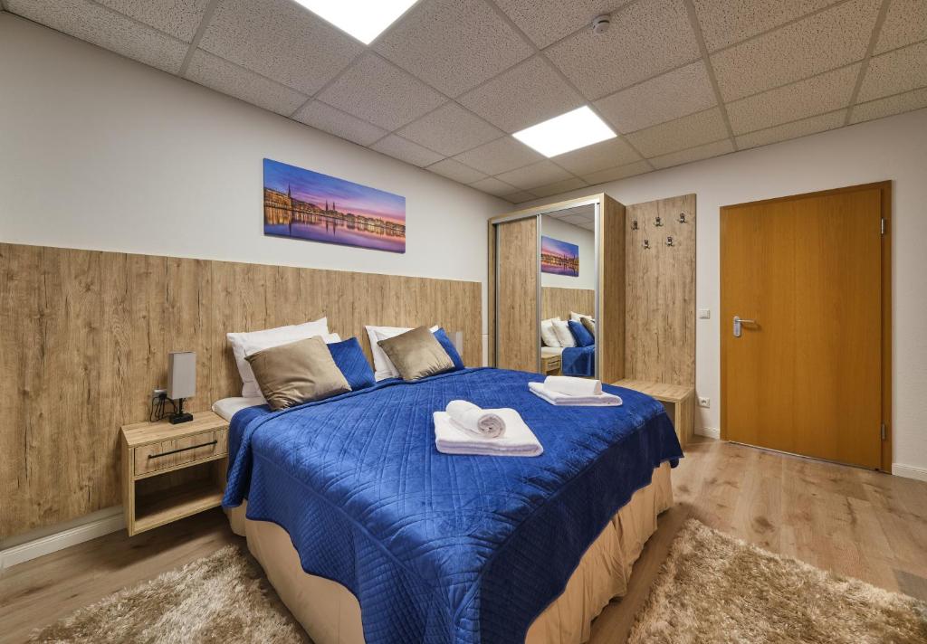 a bedroom with a large bed with a blue blanket at Sleep1c in Hamburg
