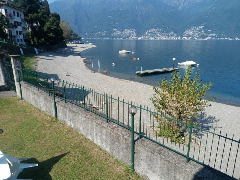a beach with a fence next to a body of water at Residenz Al Lago in Zenna