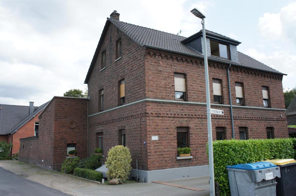 ein rotes Backsteingebäude mit schwarzem Dach in der Unterkunft Ferienwohnung Pöttershof in Krefeld