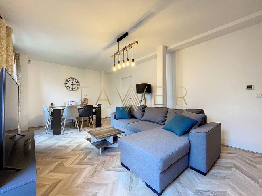ein Wohnzimmer mit einem blauen Sofa und einem Tisch in der Unterkunft Cocon urbain in LʼÎle-Saint-Denis