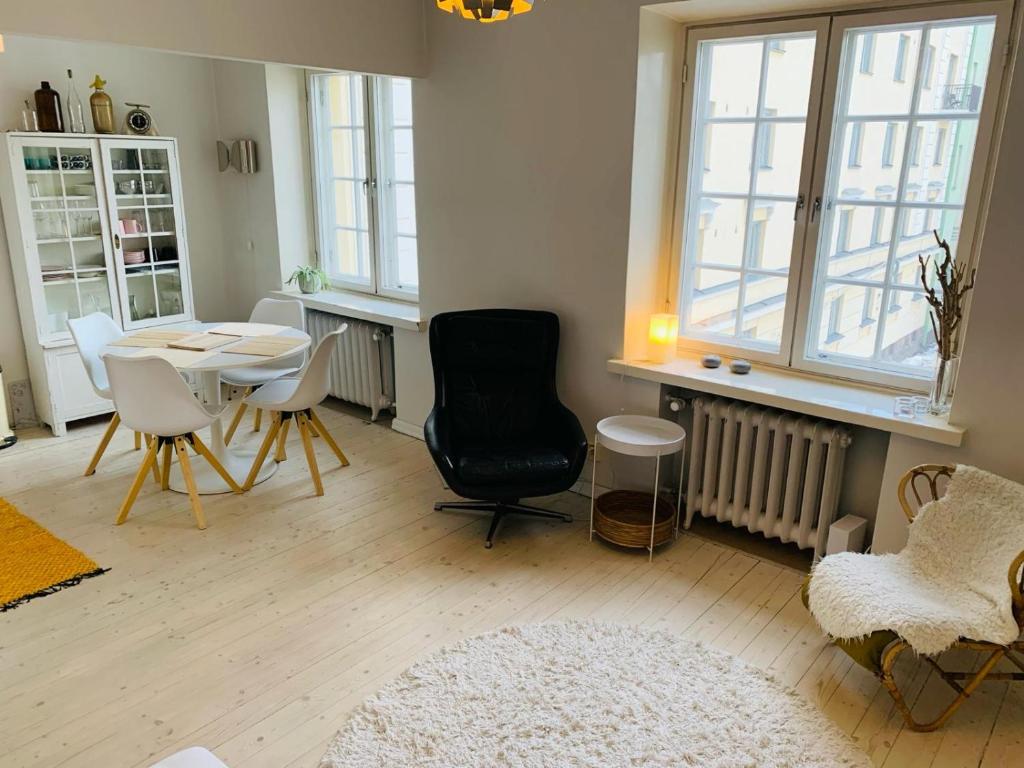 a living room with a table and chairs and windows at Charming apartment in Töölö with Nordic design in Helsinki
