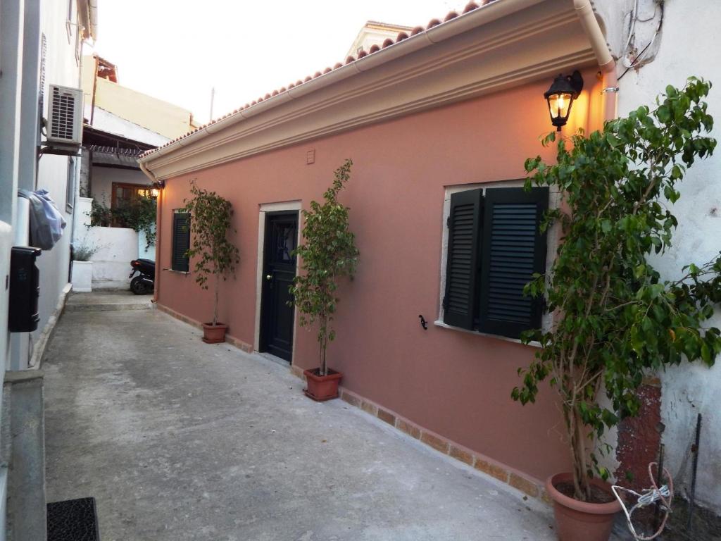 Sole Apartments - near Corfu Port في Ágios Rókkos: مبنى فيه نباتات في قدور بجانب شارع
