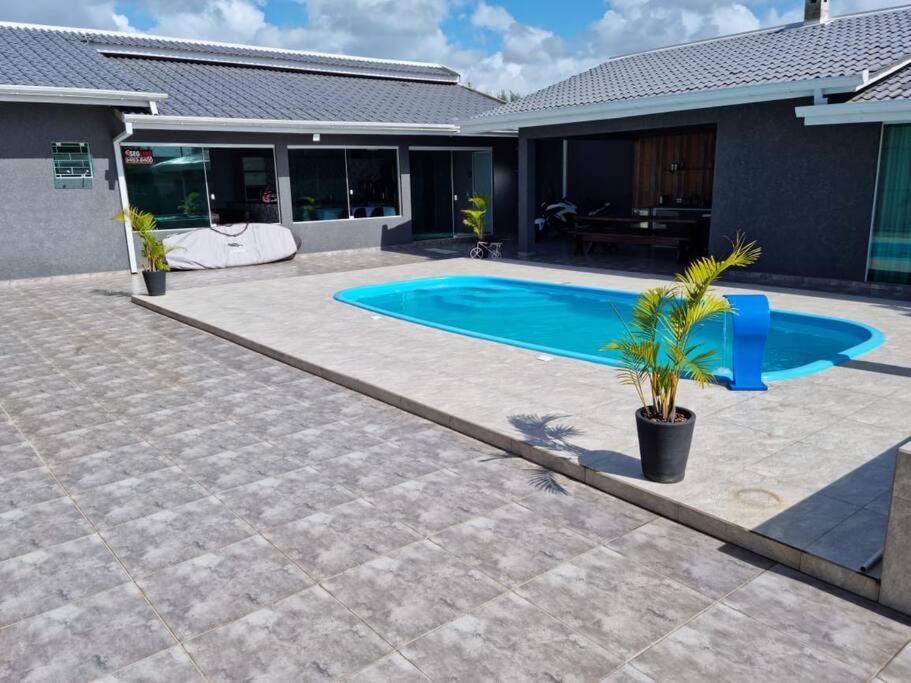 a swimming pool in the backyard of a house at Casa Alto Padrão Perto da Praia C/ Piscina Grande in Guaratuba