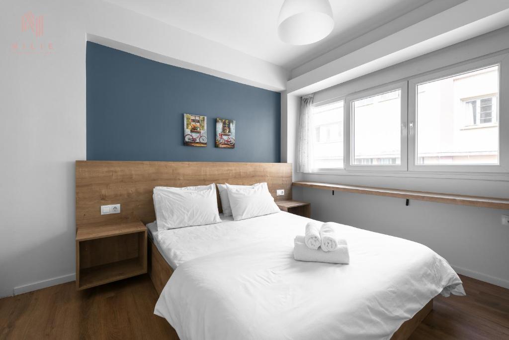 sypialnia z dużym białym łóżkiem z 2 ręcznikami w obiekcie Civilian Boutique Apartments, Nilie Hospitality MGMT w Salonikach