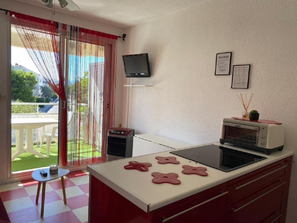 a kitchen with a counter top with a microwave at Studio cabine + Parking : proche plage in Canet-en-Roussillon