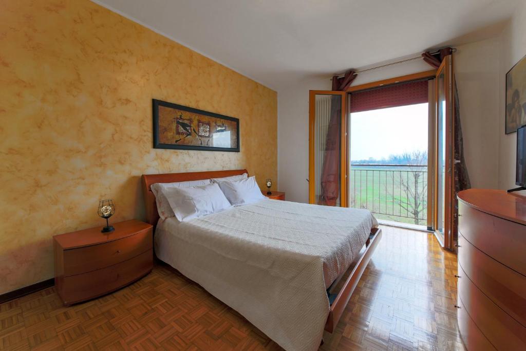 a bedroom with a bed and a large window at Free parking - 15 min to Venice in Tessera