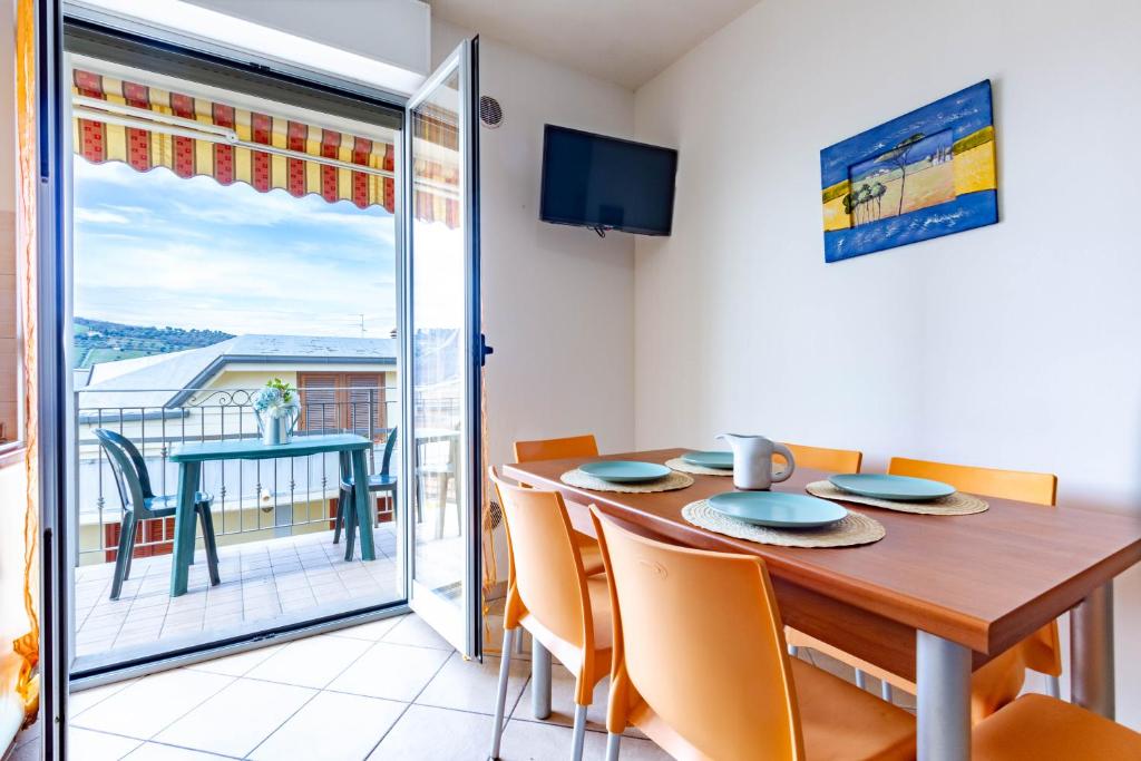 uma sala de jantar com mesa e cadeiras e uma varanda em Appartamento Pinolo Trilo INT 10 - MyHo Casa em Alba Adriatica