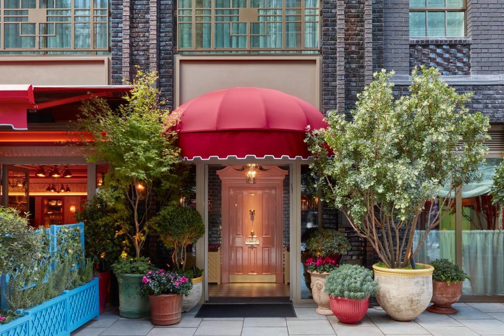 une porte d'entrée d'un bâtiment avec un parapluie rouge dans l'établissement Broadwick Soho, à Londres