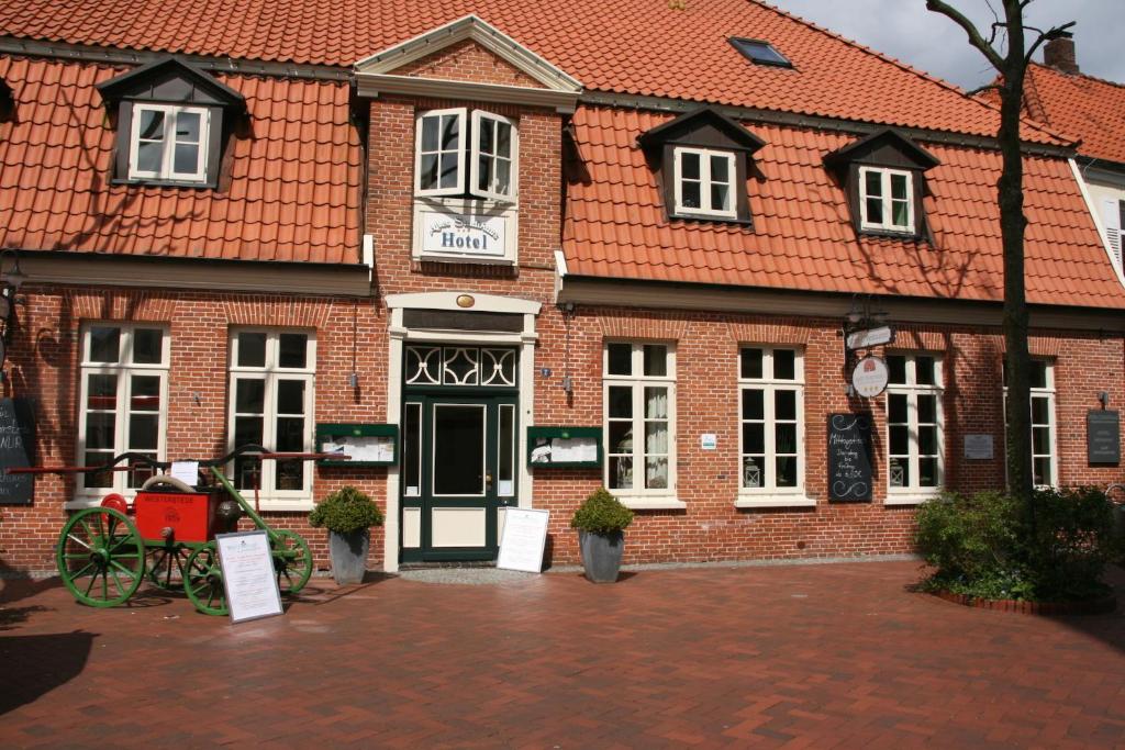 a red brick building with a red roof at Hotel Altes Stadthaus in Westerstede