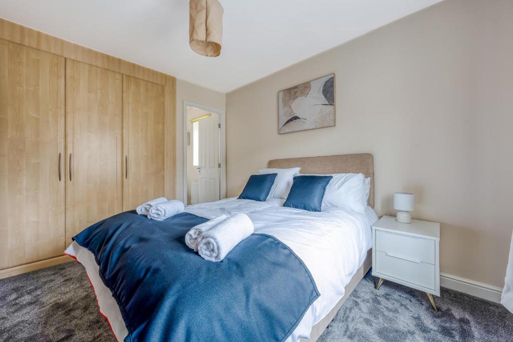 una camera da letto con un grande letto con lenzuola blu e bianche di Spectacular House with Parking a Chorley