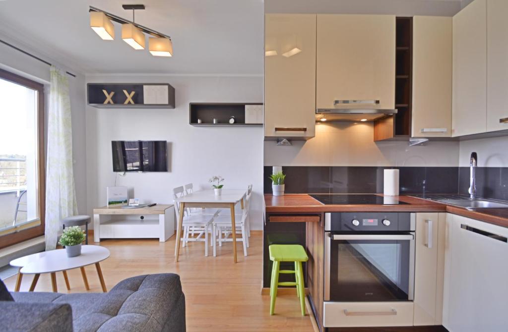 eine Küche und ein Wohnzimmer mit einem Sofa und einem Tisch in der Unterkunft Platan - Apartamenty Bryza in Świnoujście