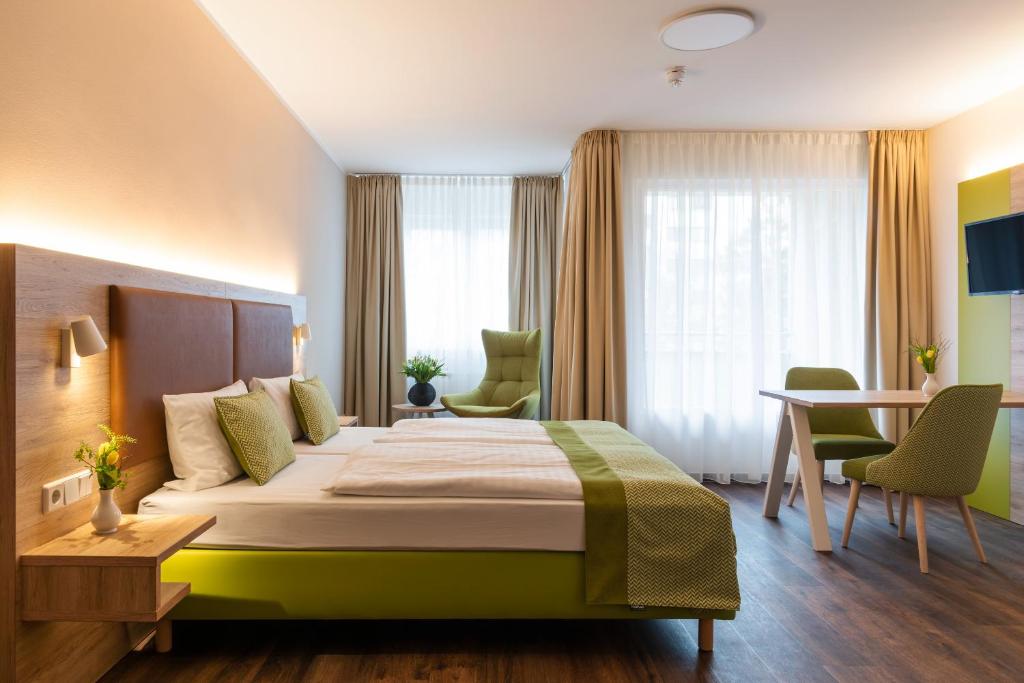 ベルリンにあるGästehaus Lazarusのベッド、テーブル、椅子が備わるホテルルームです。
