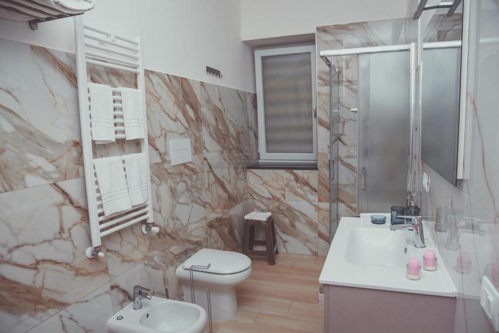 a bathroom with a toilet and a sink and a shower at Casa Vacanze Argento in Bacoli