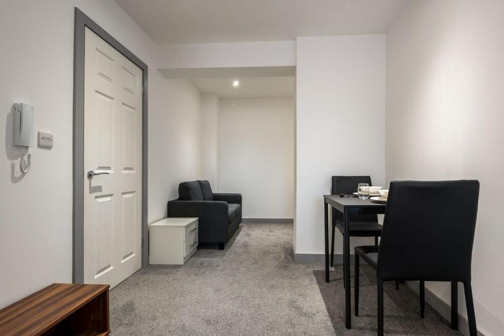 een kamer met een tafel, een stoel en een deur bij Contemporary Budget 1 Bed Apartment in Central Doncaster in Doncaster