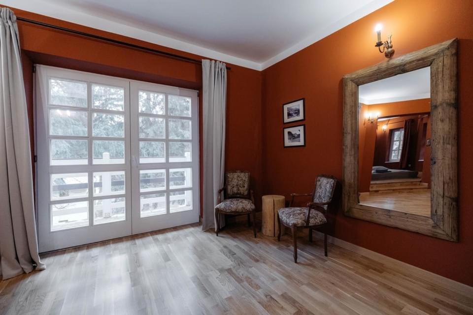 uma sala de estar com um espelho e uma janela em Miniszteri Villa em Băile Tuşnad