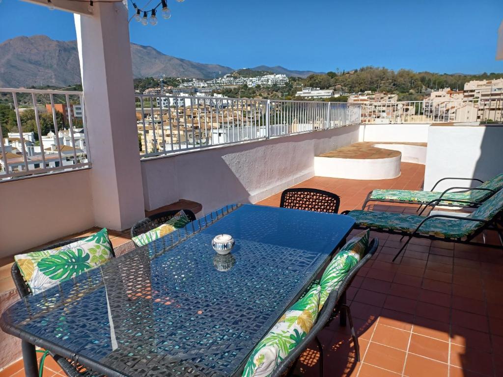 een tafel en stoelen op een balkon met uitzicht bij Ático en Estepona, Malaga in Estepona
