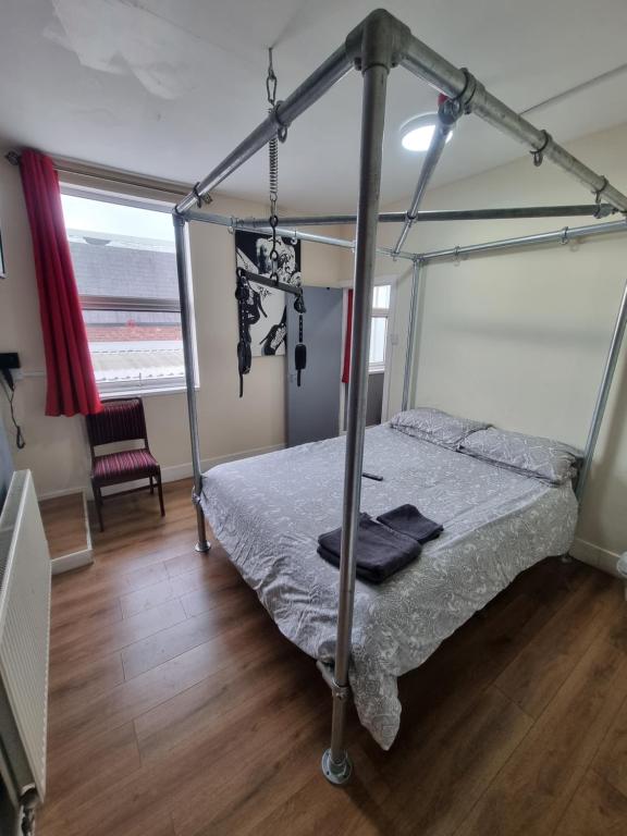 a bedroom with a bed with a metal canopy at Xtasia Adult Hotel - Adults Only in West Bromwich