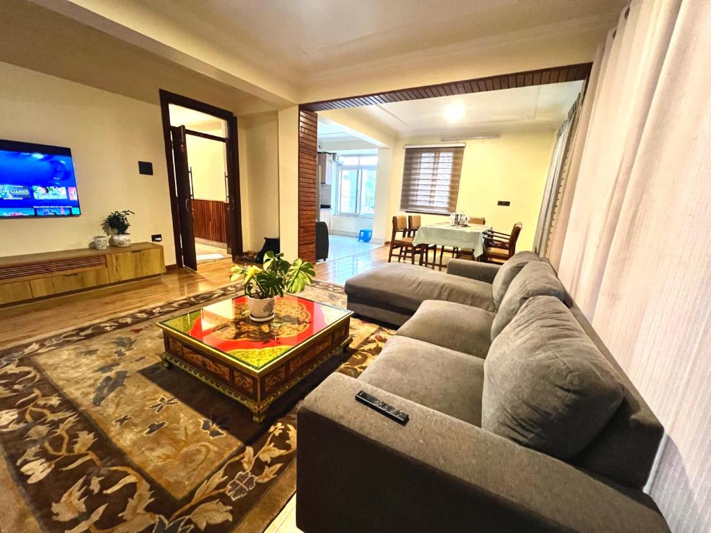 sala de estar con sofá y mesa en Bodhiz Apartments en Katmandú