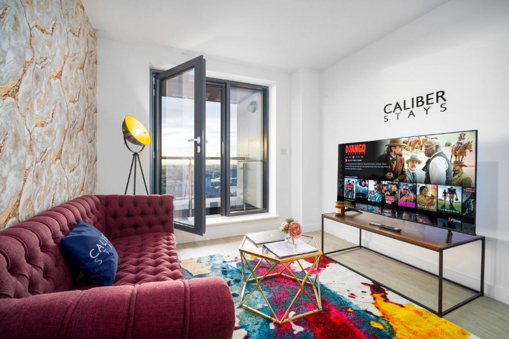 uma sala de estar com um sofá e uma televisão de ecrã plano em The Caliber Collection Luxury Apartments Manchester City Centre - CALIBER STAYS® Serviced Homes - Free WIFI Balcony Terrace Waterfront Views em Manchester